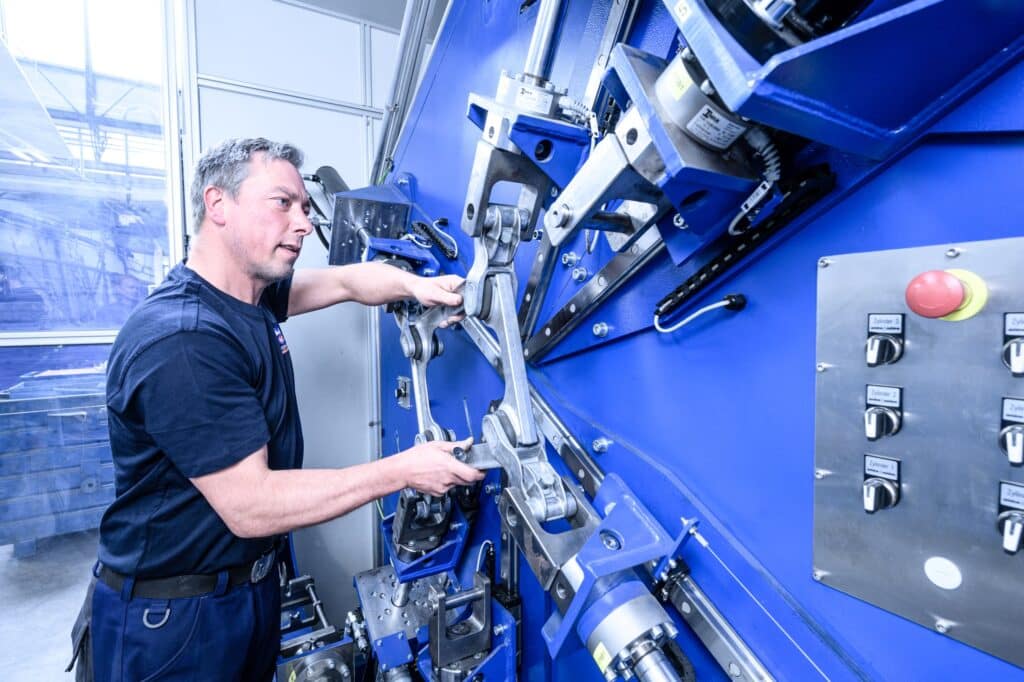 Arbeitender fixiert den Dämpfer in der Prüfanlage